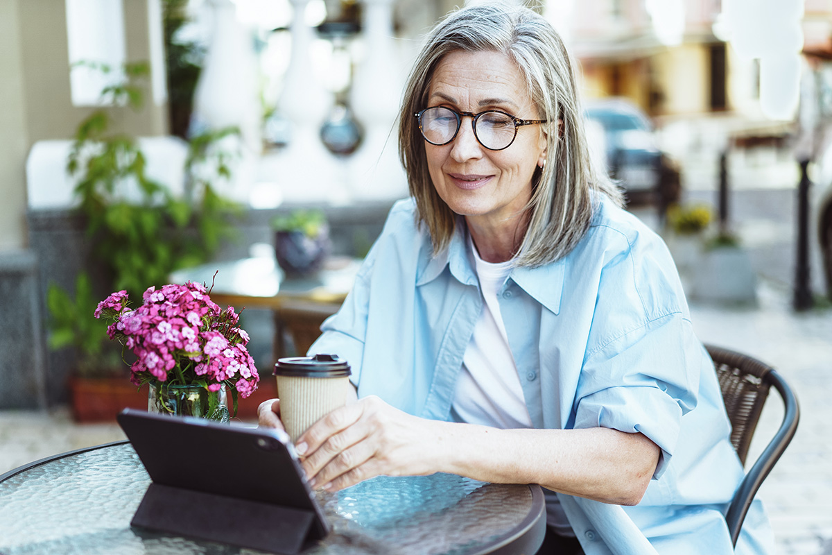 portrait-young-woman-using-phone-while-sitting-table